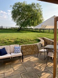 eine Terrasse mit einem Sofa, Stühlen und einem Tisch in der Unterkunft 2 Beds & living in our idyllic country Cottage in Bedford