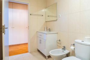 ein Badezimmer mit Toilette, Waschbecken und Spiegel in der Unterkunft Cascais Garden Cottage in Cascais + 32 Fotos