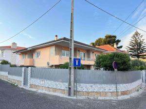 ein Zaun vor einem Haus mit einem Gebäude in der Unterkunft Cascais Garden Cottage in Cascais