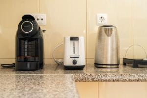 eine Kaffeemaschine und eine Kaffeemaschine auf der Theke in der Unterkunft Cascais Garden Cottage in Cascais