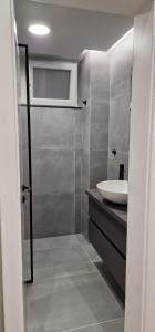 a bathroom with a white sink and a mirror at Heart of Tirana Apartment in Tirana