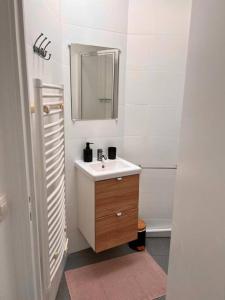 a white bathroom with a sink and a mirror at Appartement cosy - Sacré coeur in Paris