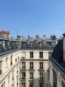 a large white building with windows and roofs at Appartement cosy - Sacré coeur in Paris
