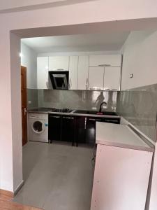 a kitchen with white cabinets and a washer and dryer at Feriz Vukaj in Hamallë +14 photos