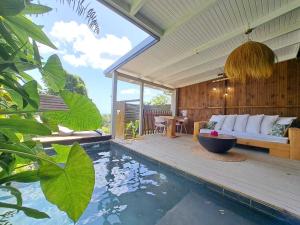 a living room with a couch and a swimming pool at EDEN FOREST Villas in Pointe-Noire