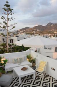 a balcony with white furniture and a view of a city at ANIMA family apartment in Naxos Chora