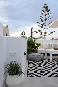 a patio with a bench and a table and plants at ANIMA family apartment in Naxos Chora