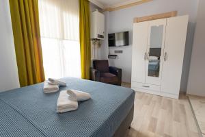 a bedroom with a bed with two towels on it at Flora Trabzon Apart in Pelitli