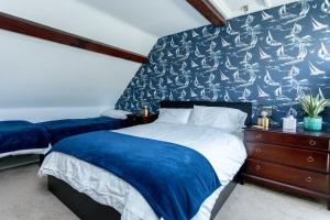 1 dormitorio con cama y pared azul en 2 The Old Schoolhouse: En-suite, hot tub, parking, pets, en Whitstable