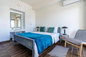 1 dormitorio blanco con 1 cama y 1 silla en Engomi Apartment en Yukarı Lakatamya