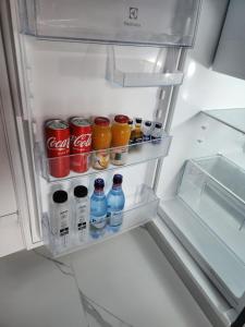 um frigorífico aberto cheio de bebidas e refrigerantes em Elite Studio Militari Residence em Chiajna