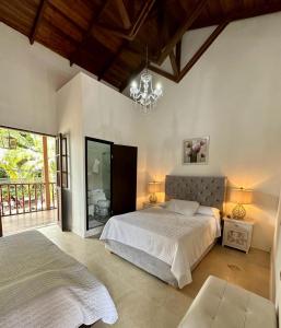 a bedroom with two beds and a chandelier at Hotel Colonial Andino - Parque principal de Pitalito in Pitalito