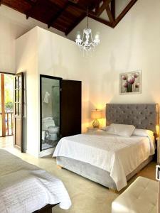 a bedroom with a large bed and a chandelier at Hotel Colonial Andino - Parque principal de Pitalito in Pitalito