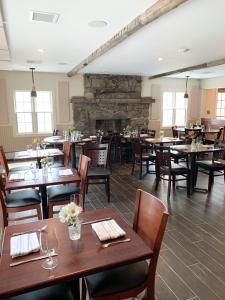 a restaurant with wooden tables and chairs and a fireplace at The General Stanton Inn in Charlestown