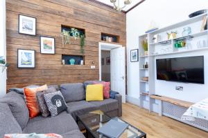 sala de estar con sofá y TV en 2 The Old Schoolhouse: En-suite, hot tub, parking, pets, en Whitstable