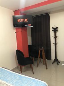 a room with a netflix sign and a table and chairs at Hostal “Malibu” in Ica
