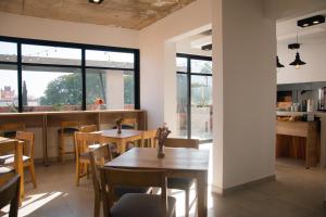 a dining room with tables and chairs and windows at Usina Studio by FMA Coliving in Salta