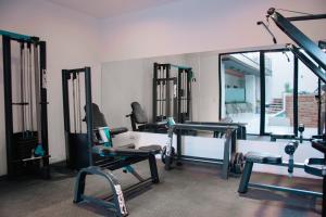 un gimnasio con varias máquinas de correr y un espejo en Usina Studio FMA-Coliving en Salta