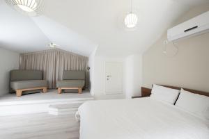 1 dormitorio blanco con 1 cama y 2 sillas en Eshkol Housing Haifa - Luxury Villa Panoramic Sea View חיפה כרמל, en Haifa