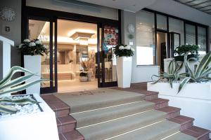 un negozio con scale che conducono alla porta d'ingresso di Hotel Savoy a Caorle