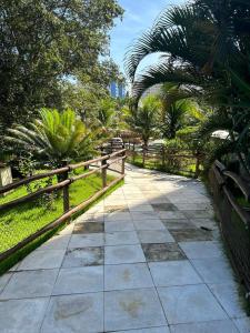 a walkway in a park with palm trees and a fence at Apartamento Thermas in Caldas Novas