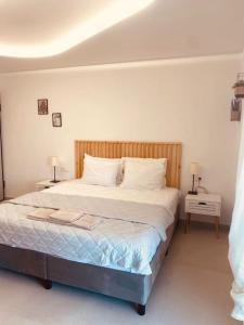 a bedroom with a bed with two tables and two lamps at Serafina suite byArtistUnknown in Vari