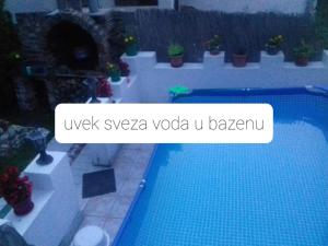 a picture of a swimming pool with a sign that reads uwxvyva vodka at Dusica in Vrnjačka Banja