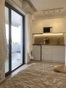 Zimmer mit einem Bett und einer Küche mit einem Fenster in der Unterkunft Serafina suite byArtistUnknown in Vari