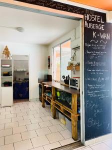 a restaurant with a chalkboard menu on the wall at Auberge K-WAN Hostel - Proche Plages in Deshaies +23 photos