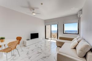 a living room with a couch and a tv at Brand new apartment Club Paraiso Ocean view in Playa Paraiso