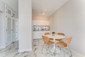 a white kitchen with a white table and chairs at Prime apartments Club Paraiso Ocean view in Playa Paraiso