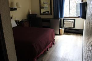 a bedroom with a bed and a television and a window at Aero Inn in Kalispell
