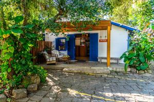 uma pequena casa azul e branca com um alpendre em Pousada Vila Jacaa em Ubatuba