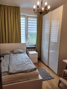 1 dormitorio con cama y ventana en Apartament Boni en Varsovia