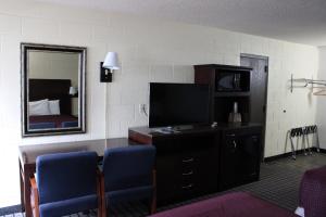 a hotel room with a television and a bedroom at Aero Inn in Kalispell