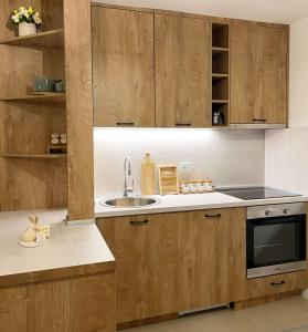 a kitchen with wooden cabinets and a sink at Mawa Cottage in Ulcinj