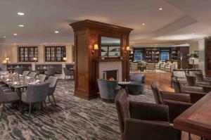 a restaurant with tables and chairs and a fireplace at Portland Harbor Hotel in Portland