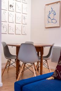una mesa con 4 sillas y un sofá azul en L'Atelier d'Artiste - refuge bohème et créatif, en Toulon