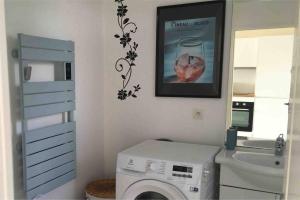 baño con lavadora y una foto en la pared en « Les 3 Hirondelles » près des Antilles de Jonzac, en Jonzac