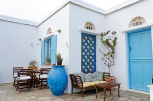 a patio with chairs and a large blue vase at m͟͞a͟͞t͟͞a͟͞t͟͞h͟͞i͟͞a͟͞ GuestHouse Tinos in Triandáros