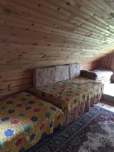 a room with two beds in a wooden attic at UZUNALİ DAĞ EVİ in Düzköy
