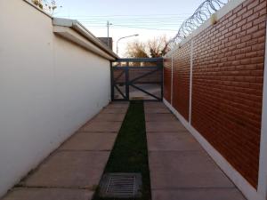 una acera junto a una pared de ladrillo con una puerta en Alojamiento Mesas en San Rafael