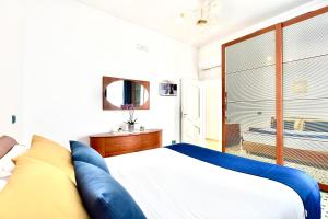 a bedroom with a large bed with blue pillows at Smeraldo Holiday House in Conca dei Marini