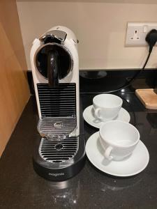 a coffee maker sitting on a counter with two cups at Luxury Apartment close to Convention Centre in Dublin