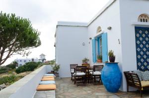 a patio with a table and chairs and a blue vase at m͟͞a͟͞t͟͞a͟͞t͟͞h͟͞i͟͞a͟͞ GuestHouse Tinos in Triandáros