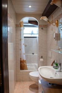 een badkamer met een wastafel, een toilet en een douche bij Le Havre de Paix in Boudevilliers