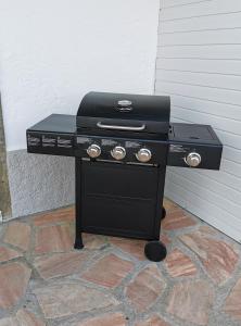 a black barbecue grill sitting on a brick floor at Le Havre de Paix in Boudevilliers