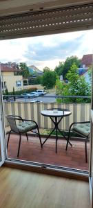 a patio with a table and chairs on a balcony at FeWo am Park- mit Ausblick auf den Europa-Park in Rust