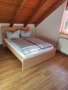 uma cama grande num quarto com pisos em madeira em FeWo am Park- mit Ausblick auf den Europa-Park em Rust