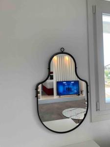 a mirror on a wall in a room with a tv at Syboro in Aloïziánika